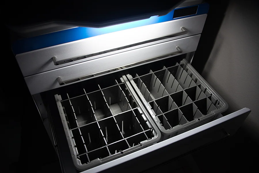 Open stainless steel freezer with blue trim and metal divider baskets for food storage organization