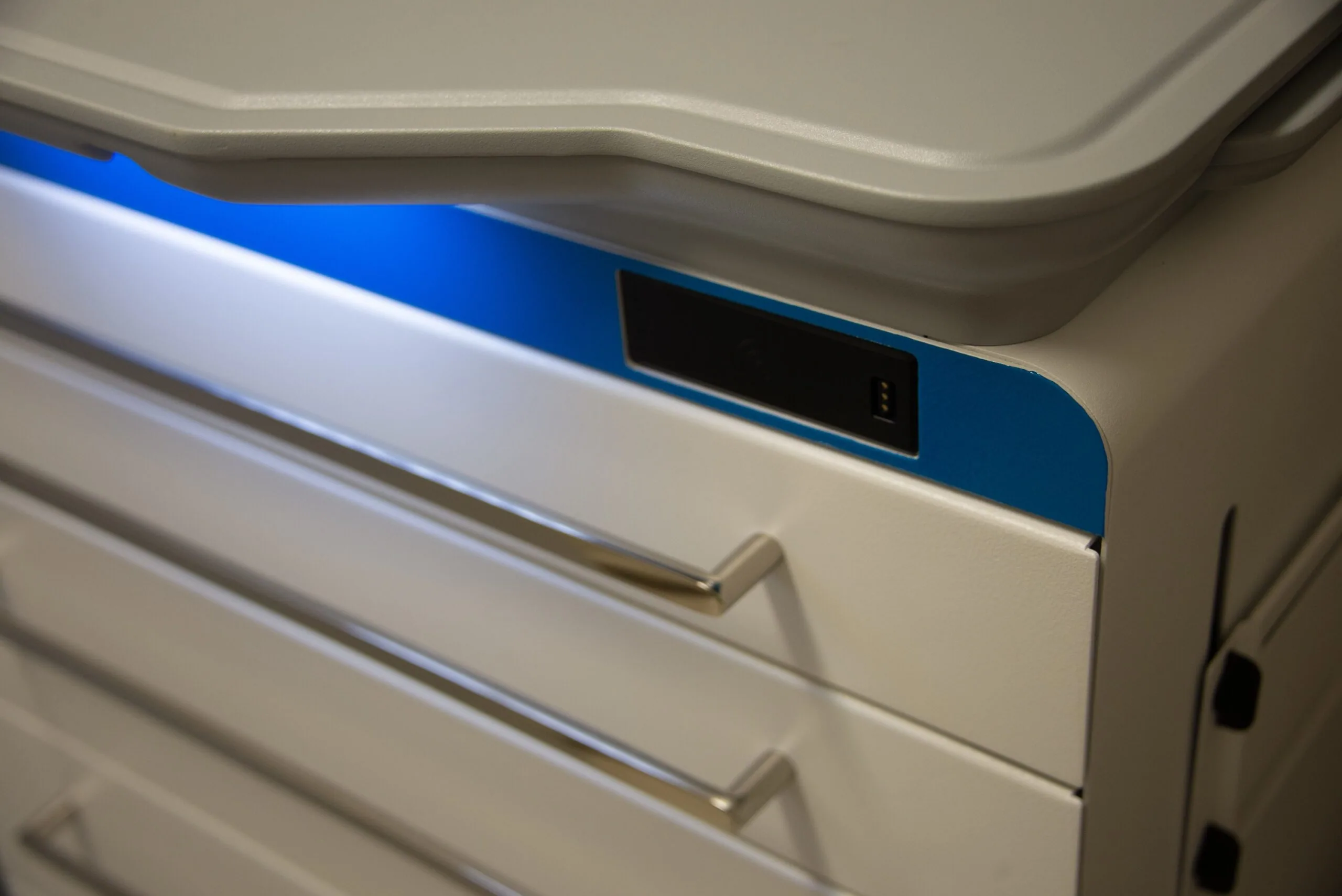 White and blue medical refrigerator with digital display and drawer handles in clinical setting